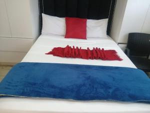 a bed with a red and blue blanket on it at Rs Air in Gqeberha