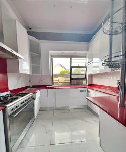 a kitchen with red and white counters and a window at Rs Air in Gqeberha