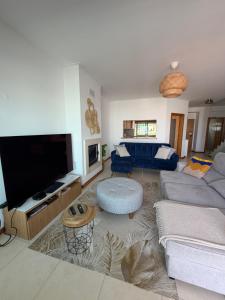 a living room with a couch and a tv at Vila Rio DOuro in Ferragudo