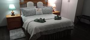 a bedroom with a bed with two stuffed animals on it at Magnolia Cottage in Cape Town