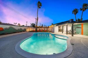 a swimming pool in front of a house at Acacia Retreat by Rather Be Properties in Palm Springs
