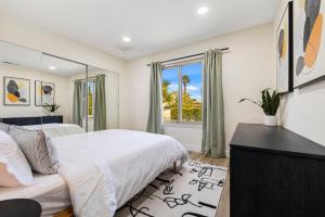 a bedroom with a bed and a desk and a window at Acacia Retreat by Rather Be Properties in Palm Springs +88 photos