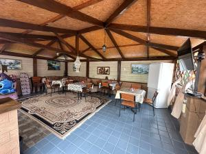 a dining room with tables and chairs and a refrigerator at Гостевой Дом ,Breeze in Chornomorsk
