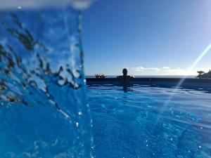 a person standing in the water in a swimming pool at Fare Tihi Moana in Tahu-Naoe