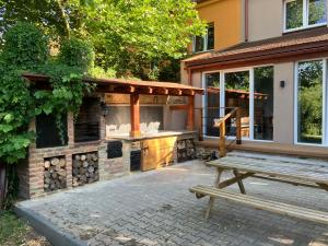 a patio with a grill and a wooden bench at U Mariki in Mikoszowa