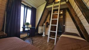 a bedroom with a ladder and a bunk bed at Горный приют in Yabluniv