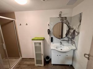 a bathroom with a sink and a mirror on the wall at Tutti Apartman in Balatonlelle +46 photos