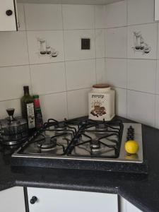 a stove top with a lemon on top of it at Hofesh Yehonatan Hadas Garden Apt in Tiberias