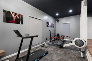 a room with a gym with a treadmill and a fan at Modern Marble - Jasper, GA - Take in Sweeping Mountain Views, Soak in the Hot Tub, Stay Active in the Home Gym, and Mix Drinks a in Jasper