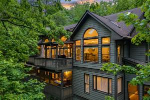 an exterior view of a house with large windows at Modern Marble - Jasper, GA - Take in Sweeping Mountain Views, Soak in the Hot Tub, Stay Active in the Home Gym, and Mix Drinks a in Jasper