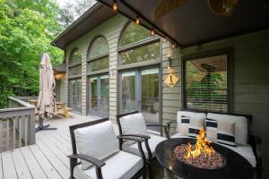 a screened in porch with a fire pit on a patio at Modern Marble - Jasper, GA - Take in Sweeping Mountain Views, Soak in the Hot Tub, Stay Active in the Home Gym, and Mix Drinks a in Jasper