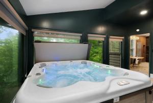 a jacuzzi tub in the middle of a room at Modern Marble - Jasper, GA - Take in Sweeping Mountain Views, Soak in the Hot Tub, Stay Active in the Home Gym, and Mix Drinks a in Jasper +79 photos