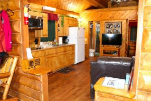 a kitchen and living room in a log cabin at Bear Den Vacation Home in Anchor Point