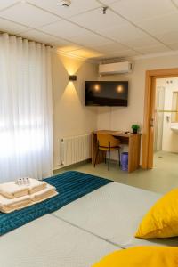 a room with a bed with a desk and a table at Hotel GR in Tobarra