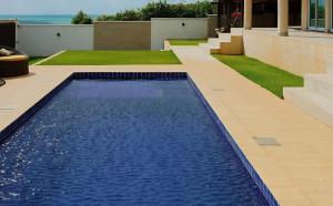 a swimming pool in a yard with a house at Vilamar in Tibau do Sul