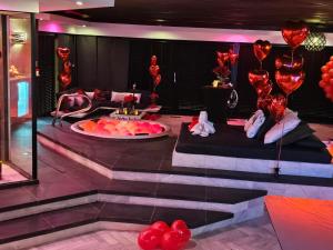 a room with red balloons and a stage with a table at Bed & Wellness Malina Deluxe zwembad suite in Lelystad