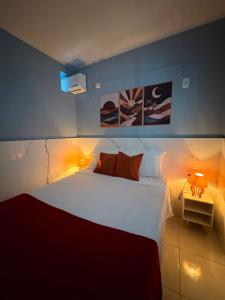 a bedroom with a large white bed with a red blanket at Hidromassagem cromoterapia ar condicionado lareira in Imbé