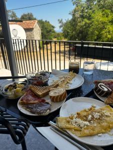 ein Tisch mit Tellern voller Essen auf einem Tisch in der Unterkunft Aetheria resort in Samothráki