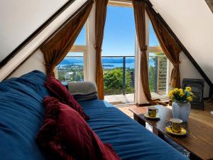 a living room with a blue couch and a large window at Fjord Panorama Lodge in Strand
