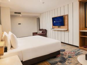 a hotel room with a bed and a tv at Zenith Sunshine in Lebakwangi