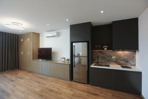 a kitchen with black cabinets and a counter top at BH Riverside Hotel in Hanoi