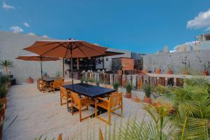 a patio with tables and chairs and an umbrella at Casa Levonka in Oaxaca City