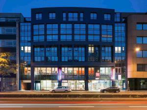 two cars parked in front of a building at night at ibis Nürnberg Hauptbahnhof in Nuremberg