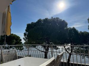 a table and chairs on a balcony overlooking the water at BeachfrontGrado Seaview Apartment Costa Azzurra in Grado