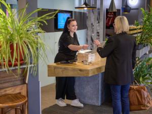 two women standing at a counter in a store at ibis Falaise Coeur de Normandie in Falaise