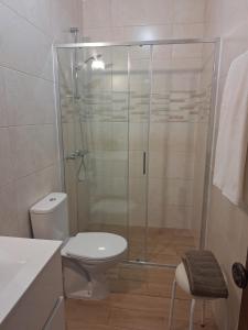 a bathroom with a toilet and a glass shower at Casa Reis in Odeceixe