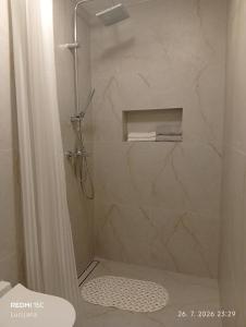 a bathroom with a shower with a shower curtain at Apartma AURORA in Dekani