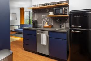 a kitchen with blue cabinets and a black refrigerator at The Foreside Inn in Kittery