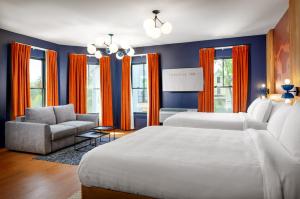 a bedroom with two beds and a chair and a couch at The Foreside Inn in Kittery