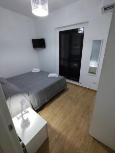 a bedroom with a bed and a table and a window at Casa Engy in Rocca Imperiale