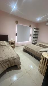 a room with two beds and a white projection screen at Las Moras in Ezeiza