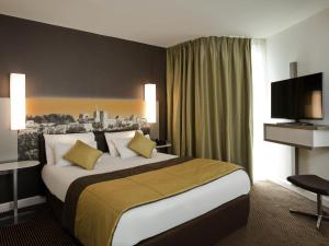 a hotel room with a large bed and a television at Mercure Avignon Centre Palais des Papes in Avignon