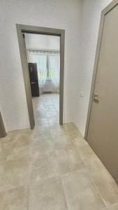 an empty room with a door and a tile floor at НОВИЙ ЖК ОДЕСЬКІ ТРАДИЦІЇ НА ГЛУШКО!є підземний паркінг! in Odesa