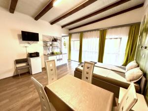 a living room with a couch and a table and chairs at Tutti Apartman in Balatonlelle
