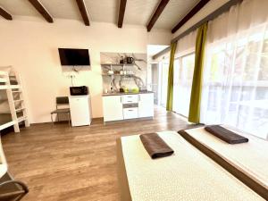 a large room with two beds and a kitchen at Tutti Apartman in Balatonlelle