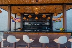 a bar with white chairs in front of it at Casa Levonka in Oaxaca City