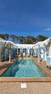 a swimming pool with a deck and a white house at CASA MAGALI in Sant Francesc Xavier