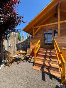 a small cabin with a deck and a table and chairs at Naturcamp Duvendiek Blockhäuschen in Niepars