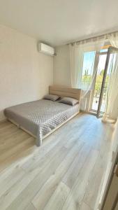 a bedroom with a bed and a large window at НОВИЙ ЖК ОДЕСЬКІ ТРАДИЦІЇ НА ГЛУШКО!є підземний паркінг! in Odesa +3 photos