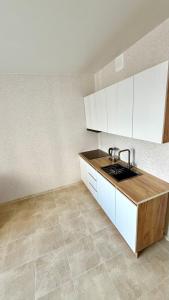 a kitchen with a sink and white cabinets at НОВИЙ ЖК ОДЕСЬКІ ТРАДИЦІЇ НА ГЛУШКО!є підземний паркінг! in Odesa