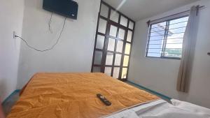 a bedroom with a bed with a television on the wall at Casa ie in Santa María Azompa