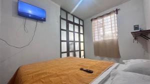 a bedroom with a bed with a tv on the wall at Casa ie in Santa María Azompa +1 photo