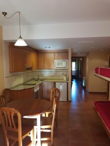 a kitchen and dining room with a table and chairs at APARTAMENTOS Hotel TurMo in Labuerda