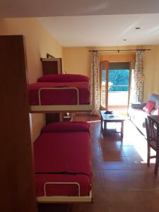 a room with three bunk beds and a living room at APARTAMENTOS Hotel TurMo in Labuerda