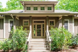 a house with a green door and stairs at - Dawsonville, GA - Take in Beautiful Lake Views, Kick Off a Game of Foosball, Cozy Up by the Fireplace, and Unwind on the Scree in Dawsonville