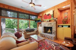 a living room with a couch and a fireplace at - Dawsonville, GA - Take in Beautiful Lake Views, Kick Off a Game of Foosball, Cozy Up by the Fireplace, and Unwind on the Scree in Dawsonville